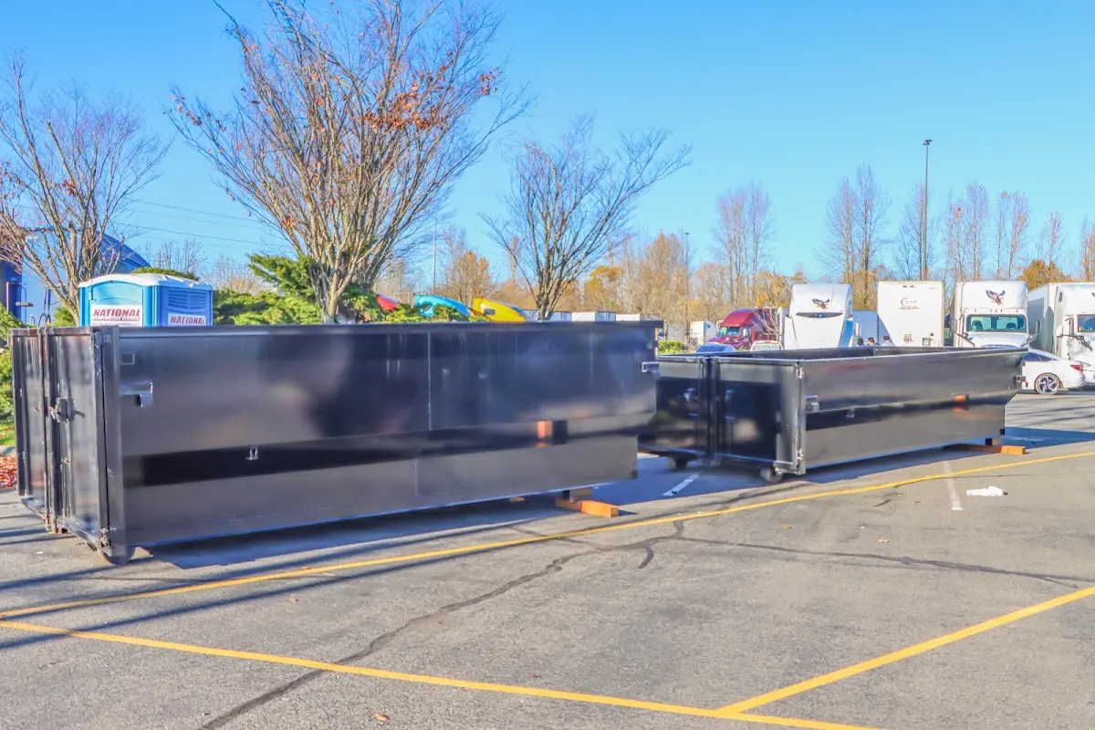 Professional dumpster rental service with roll-off container on residential driveway in Fairbanks